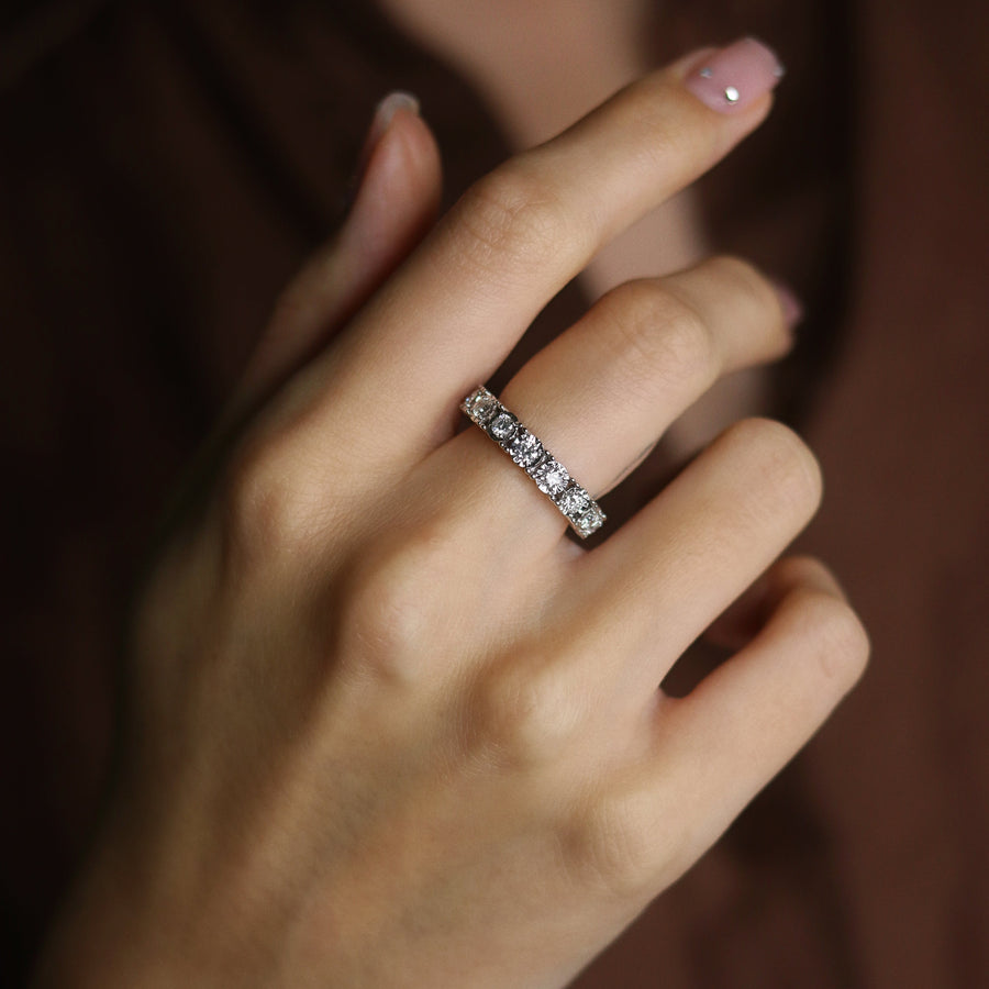 Close-up of a hand wearing a diamond ring with a blurred background